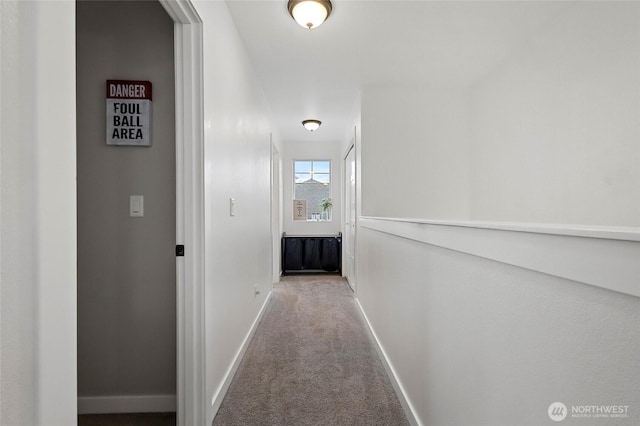 hall featuring carpet flooring and baseboards