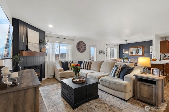 living room with recessed lighting, wood finished floors, and a large fireplace