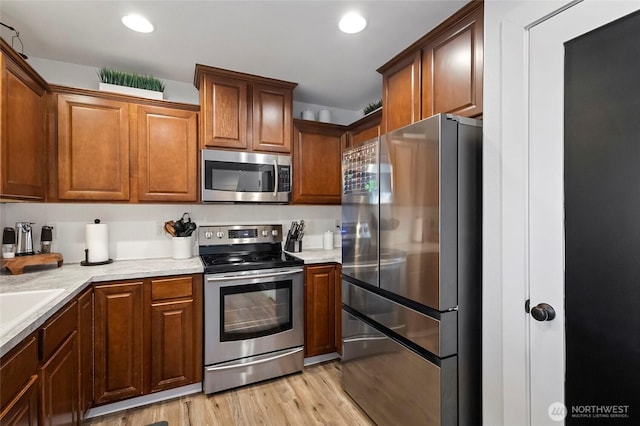 kitchen with recessed lighting, light wood-type flooring, appliances with stainless steel finishes, and light countertops