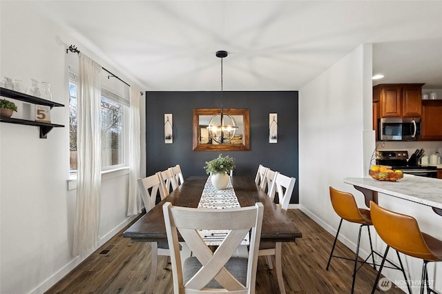 dining room with an inviting chandelier, dark wood-type flooring, visible vents, and baseboards