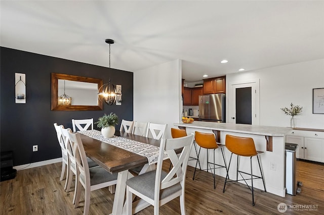 dining space with recessed lighting, baseboards, an inviting chandelier, and dark wood-style flooring