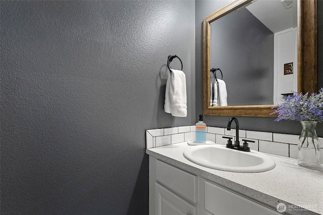 bathroom with vanity and a textured wall