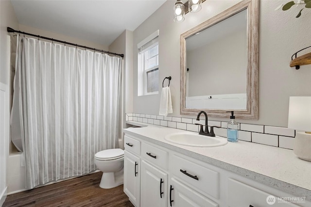 full bath with shower / bathtub combination with curtain, toilet, backsplash, wood finished floors, and vanity