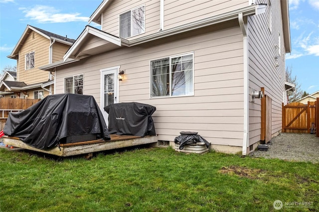 rear view of property with a lawn and fence