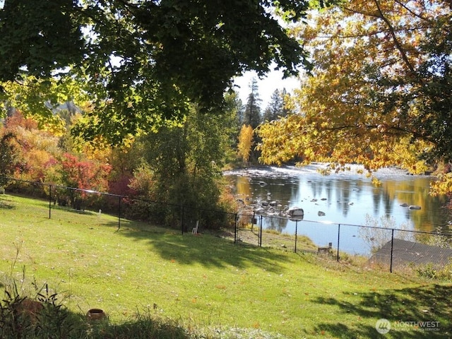 view of yard featuring a water view and fence