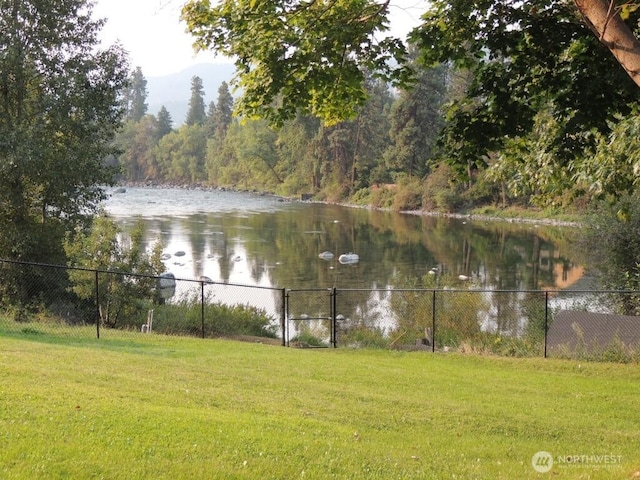 water view featuring fence and a forest view