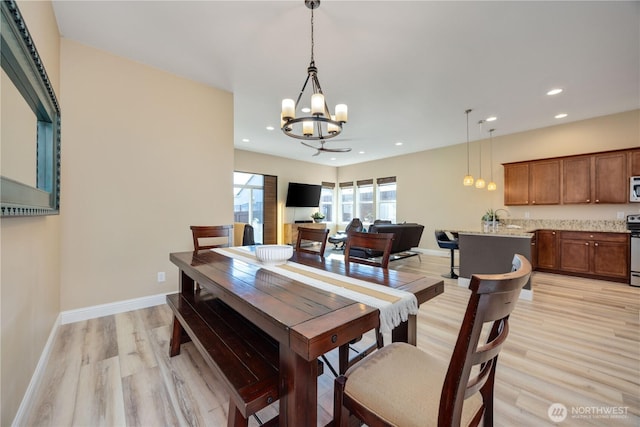 dining area with light wood-style floors, recessed lighting, a notable chandelier, and baseboards