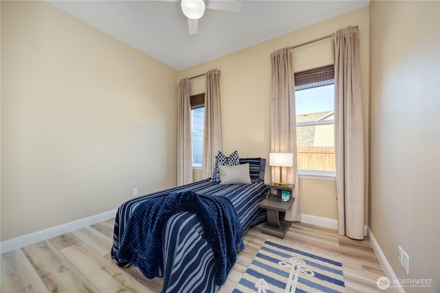 bedroom featuring wood finished floors, a ceiling fan, and baseboards