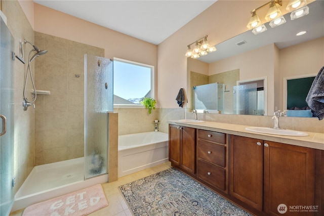 full bath with tile patterned flooring, visible vents, a sink, and a shower stall