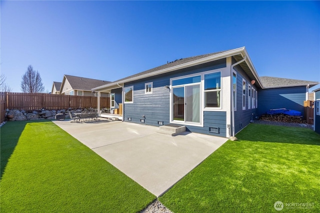 back of house featuring a yard, a patio area, and fence