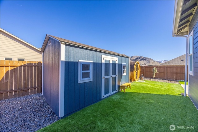 view of shed featuring a fenced backyard and a mountain view