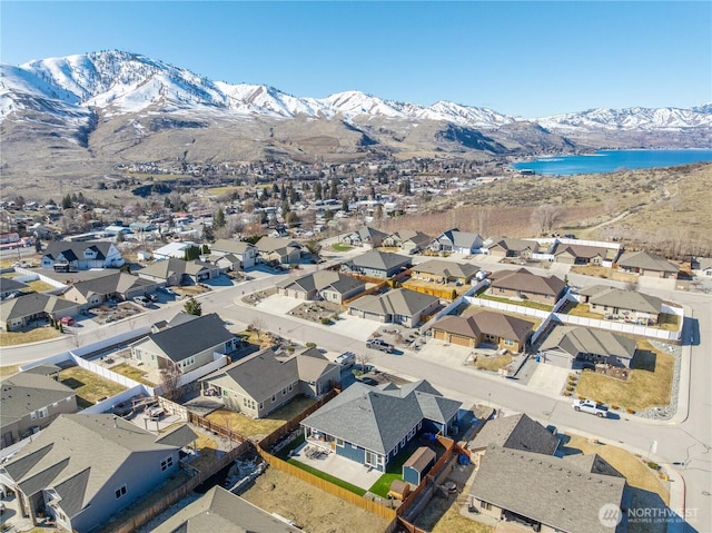 drone / aerial view with a water and mountain view and a residential view