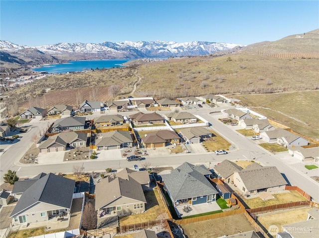 drone / aerial view featuring a residential view and a water and mountain view