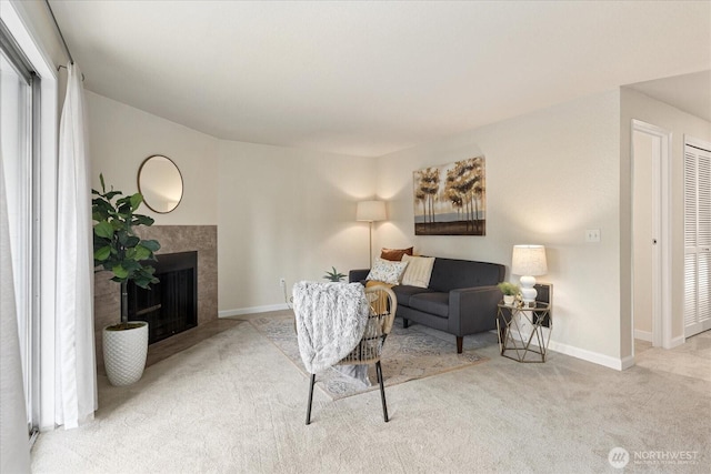 carpeted living area with a tile fireplace and baseboards