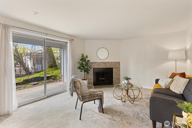 carpeted living room with a fireplace and baseboards