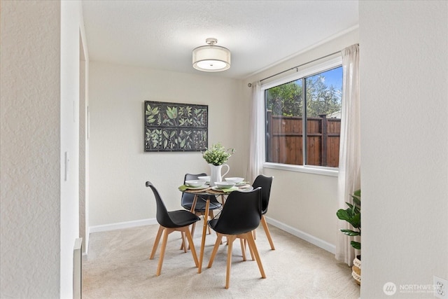 carpeted dining area with baseboards