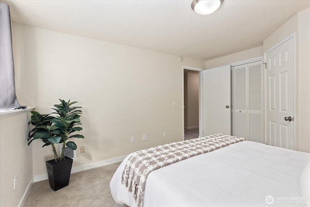 bedroom featuring a closet, light colored carpet, and baseboards