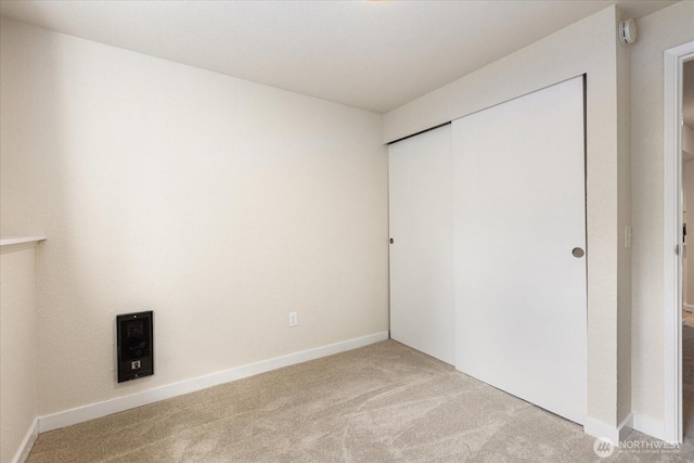 unfurnished bedroom with carpet, a closet, and baseboards