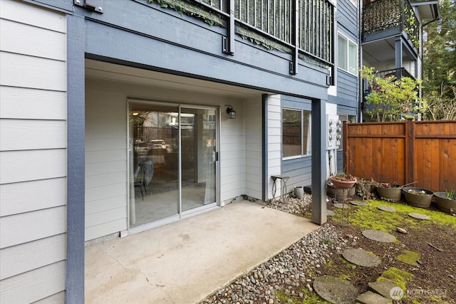 doorway to property featuring fence and a patio