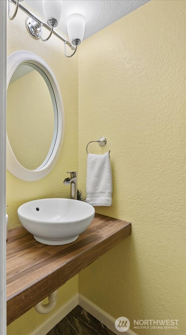 bathroom featuring baseboards and a sink