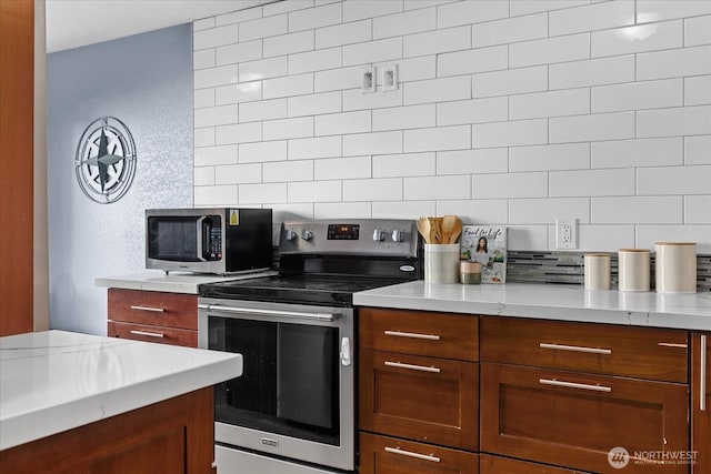 kitchen with appliances with stainless steel finishes and backsplash