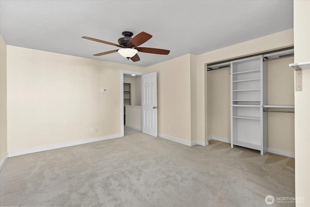 unfurnished bedroom featuring carpet, a closet, baseboards, and a barn door