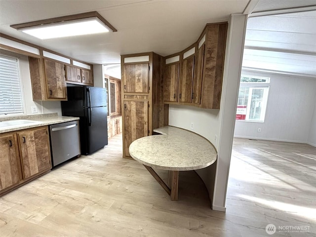 kitchen featuring light wood-style flooring, a sink, freestanding refrigerator, light countertops, and dishwasher