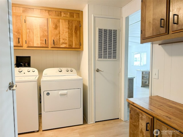 11436 SE 208th St Unit 106, Kent, WA 98031 - laundry area featuring separate washer and dryer, light wood finished floors, and cabinet space