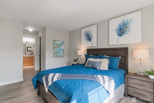 bedroom featuring ensuite bath, baseboards, and wood finished floors