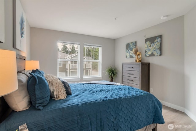 bedroom with light wood-style floors and baseboards