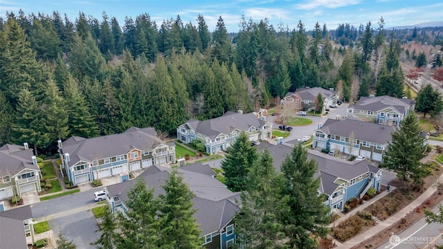 birds eye view of property featuring a residential view and a wooded view