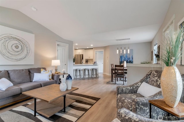 living area with lofted ceiling, baseboards, light wood finished floors, and recessed lighting