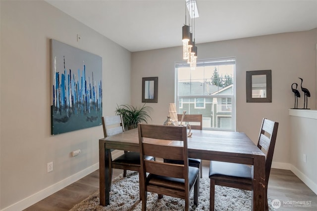 dining space with wood finished floors and baseboards