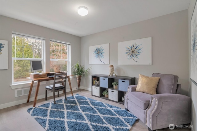 office featuring baseboards, visible vents, and wood finished floors