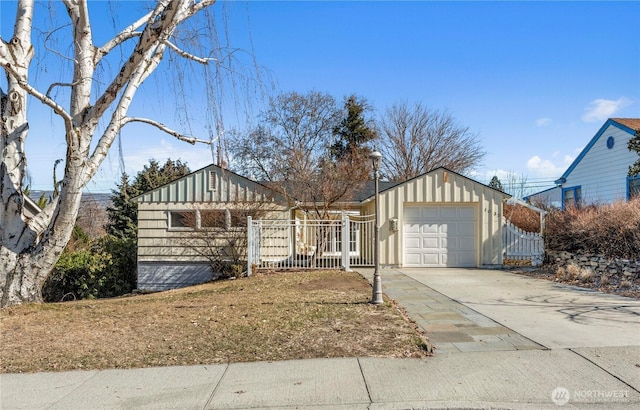 view of front of property with an attached garage, fence, board and batten siding, and concrete driveway