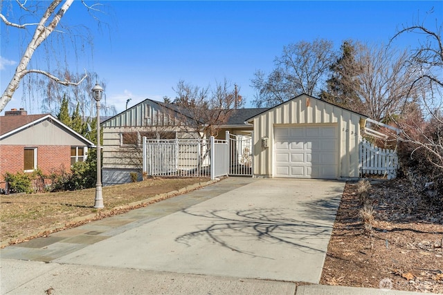 ranch-style home featuring driveway, an attached garage, fence, and board and batten siding