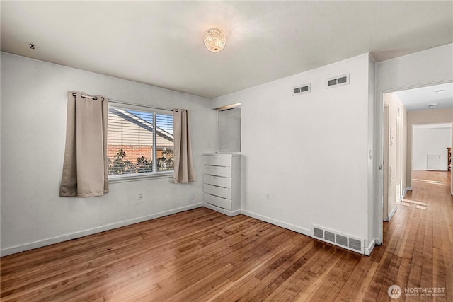 unfurnished bedroom with baseboards, visible vents, and hardwood / wood-style floors