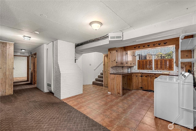 kitchen with light carpet, brown cabinetry, a textured ceiling, and visible vents