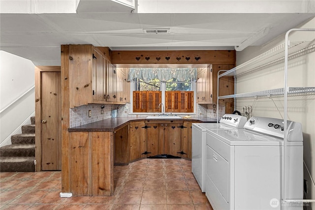 laundry area with light tile patterned flooring, a sink, visible vents, cabinet space, and washer and clothes dryer