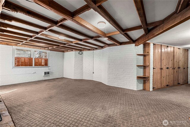 below grade area with brick wall and carpet