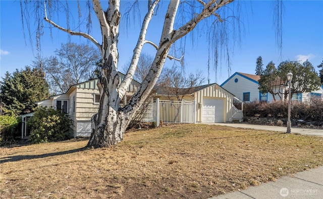 view of side of home with board and batten siding, driveway, and fence