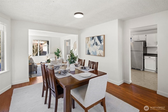 dining area featuring a textured ceiling and wood finished floors