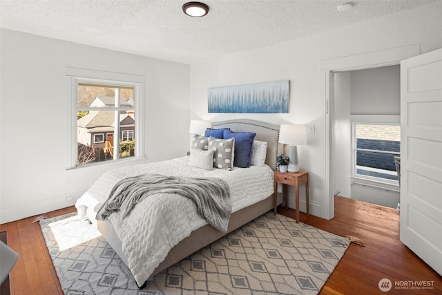 bedroom with a textured ceiling and wood finished floors