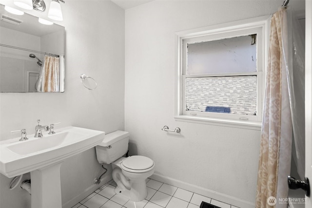 bathroom featuring tile patterned flooring, toilet, a sink, visible vents, and baseboards