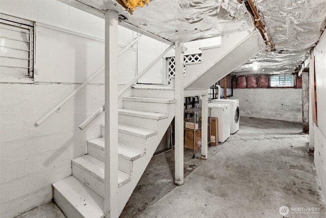 below grade area featuring washing machine and clothes dryer and stairs