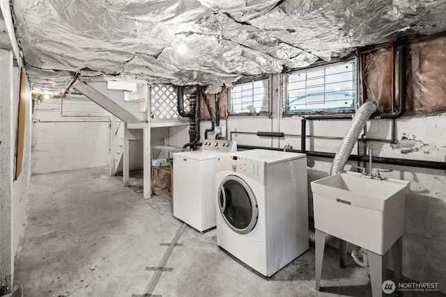 washroom with laundry area, a sink, and washing machine and clothes dryer