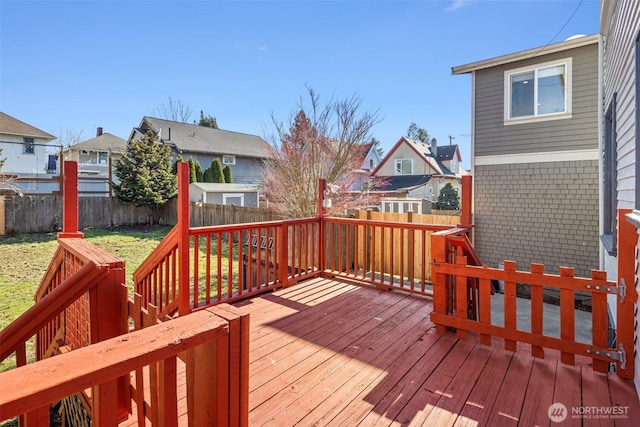 wooden terrace featuring a fenced backyard and a residential view