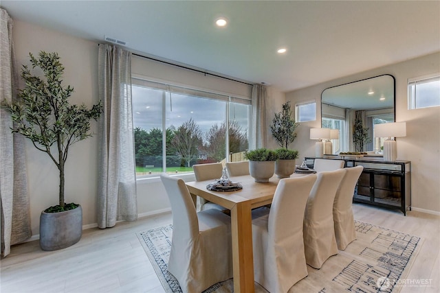 dining space featuring baseboards, recessed lighting, light wood-type flooring, and a healthy amount of sunlight