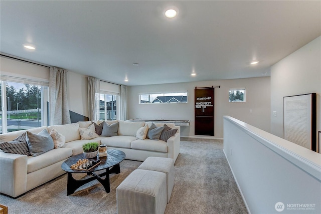 living room with recessed lighting, carpet flooring, baseboards, and a barn door