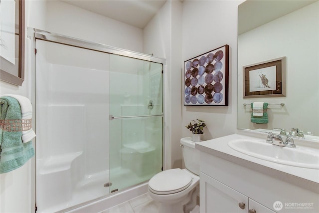 bathroom featuring toilet, a shower stall, and vanity